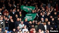 FILE - Crystal Palace fans mock the opposing team with flags of Saudi Arabia before a match between Crystal Palace and Newcastle United, in Selhurst Park, London, Oct. 23, 2021. (Action Images via Reuters)