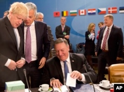 El secretario de Estado de EE.UU. Mike Pompeo, a la derecha, habla con el canciller británico Boris Johnson, a la izquierda, y con el ministro belga de Asuntos Exteriores, Didier Reynders, durante una reunión del Consejo del Atlántico Norte en la sede de la OTAN en Bruselas, el viernes 27 de abril de 2018.