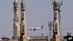 FILE - An EgyptAir plane flies past minarets of a mosque as it approaches Cairo International Airport, in Cairo, Egypt, May 21, 2016.