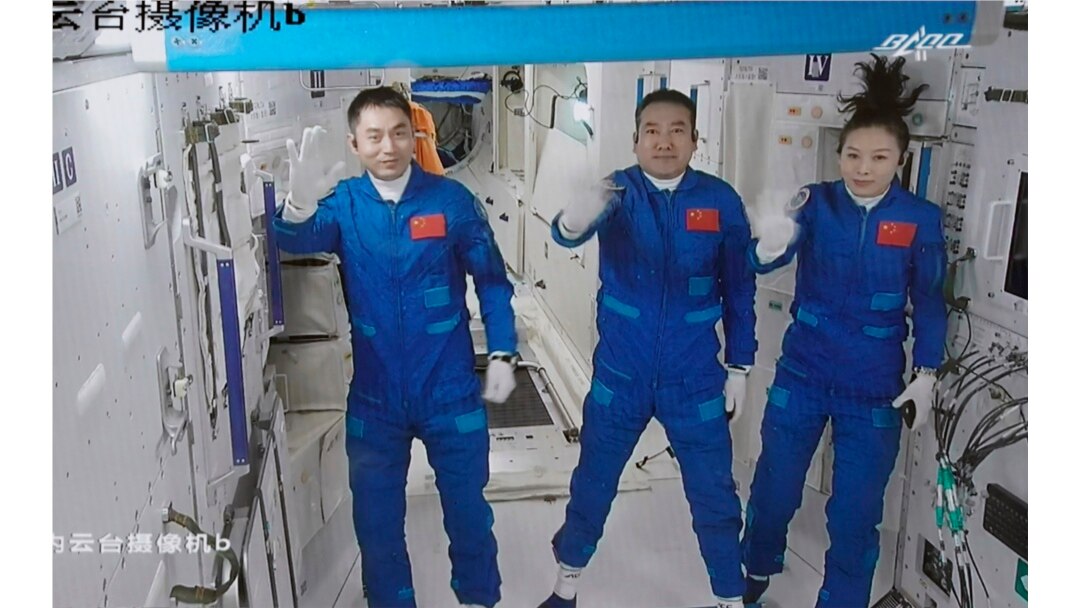 Screen image captured at Beijing Aerospace Control Center in Beijing, China, Oct. 16, 2021, shows three Chinese astronauts waving after entering the space station core module Tianhe.
