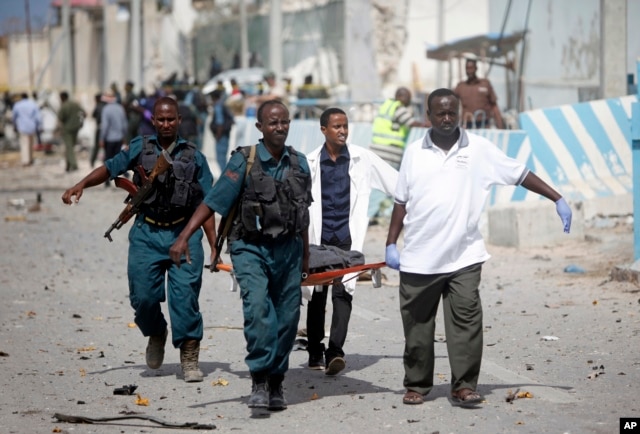 United Nations office guards and Somalian soldiers carry the dead body of their colleague who was killed in a suicide car bomb outside the UN's office in Mogadishu, Somalia on July 26, 2016