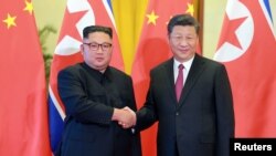 시진핑 중국 국가주석(오른쪽)과 김정은 북한 국무위원장이 지난 6월 베이징에서 정상회담에 앞서 악수하고 있다.