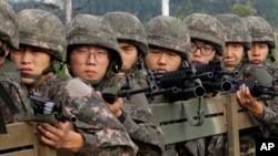 Tentara Angkatan Darat Korea Selatan mengendarai truk di Paju, sebelah selatan zona demiliterisasi dua Korea, Korea Selatan (24/8). (AP/Ahn Young-joon)