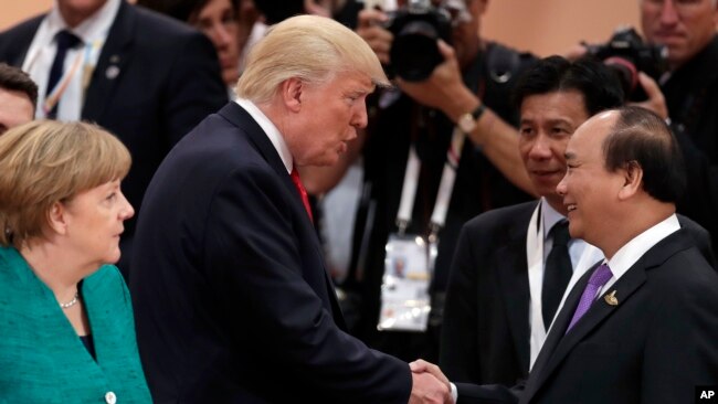 Berlin cho biết Việt Nam đã yêu cầu cho dẫn độ ông Thanh về Việt Nam tại hội nghị G20 ở Đức. Trong ảnh là Thủ tướng Đức Merkel nhìn Tổng thống Trump và Thủ tướng Việt Nam Nguyễn Xuân Phúc bắt tay nhau.