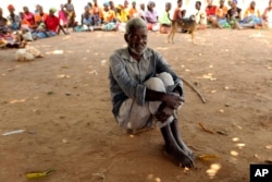 A man waits to receive food aid outside a camp for displaced survivors of Cyclone Idai in Dombe, Mozambique, April 4, 2019.