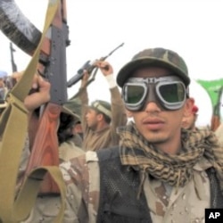 A Libyan government soldier poses for the camera at the west gate of town Ajdabiyah, March 17, 2011