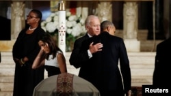 President Barack Obama, back to camera, hugs Vice President Joe Biden during the funeral of his son former Delaware Attorney General Beau Biden as Biden's widow Hallie, left, passes her husband's casket at St. Anthony of Padua church in Wilimington, Del.,