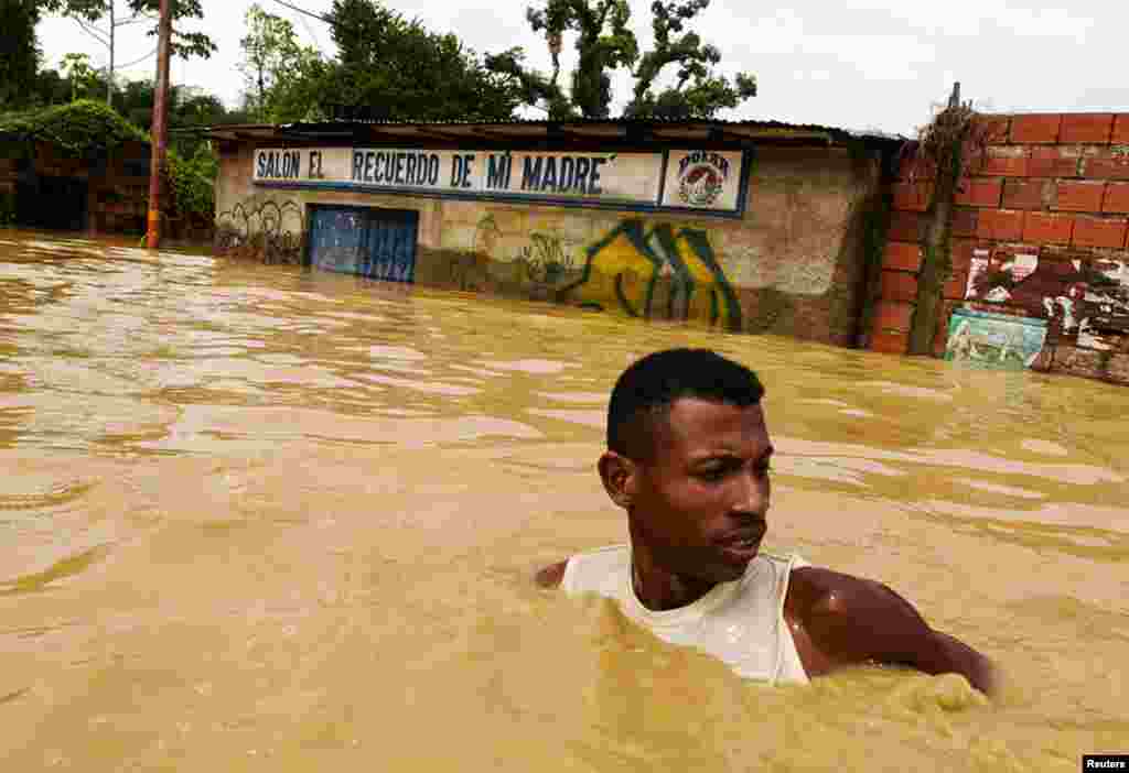 A man walks in the flooded streets in Barlovento in the state of Miranda outside Caracas December 1. (REUTERS/Miranda Government/Handout)