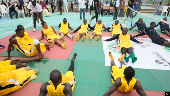 FILE — Peacemaker Azuegbulam, 27, Africa's first gold medalist at the Invictus Games, center left, warms up before an exhibition sitting volleyball match in Abuja Nigeria, May 11, 2024.