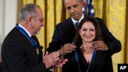 Emilio Estefan observa al presidente Barack Obama colocar a su esposa Gloria la Medalla Presidencial de la Libertad, durante una ceremonia en la Casa Blanca. Noviembre 24 de 2015.