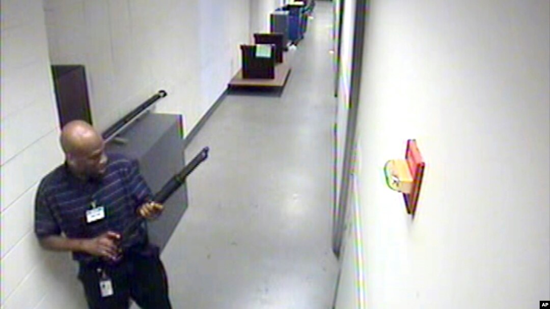FILE - Aaron Alexis moves through the hallways of Building #197 at the Washington Navy Yard, Sept. 16, 2013.