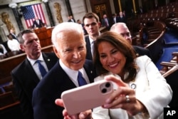 Başkan Joe Biden salona girerken Kongre üyeleriyle selamlaştı ve bazı Kongre üyelerinin 4 yıl daha sloganları eşliğinde kürsüye doğru yürüdü.