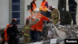 Emergency personnel work at the site of a collapsed building in the town of Durres, following Tuesday's powerful earthquake that shook Albania, Nov. 27, 2019. 