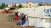 (FILE) People already displaced by conflict, rest by tents at a makeshift campsite they were evacuated to following deadly floods in the eastern city of Kassala on August 11, 2024.