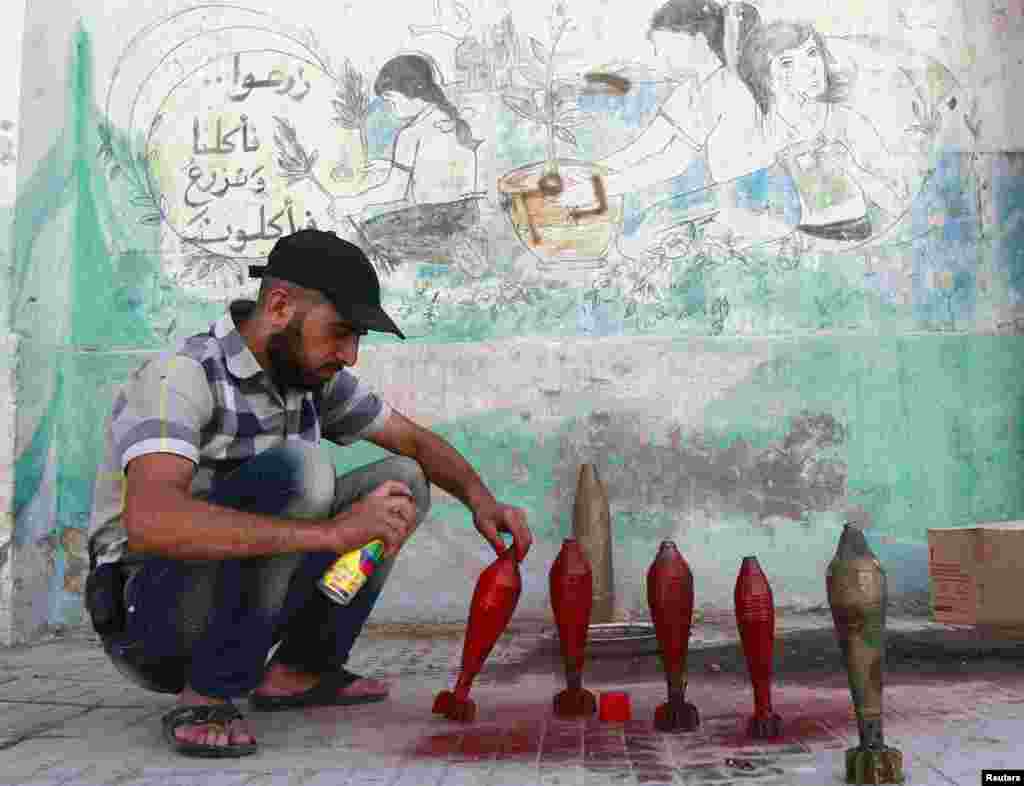 A Free Syrian Army fighter spray paints on improvised mortar shells at a weapons factory in Aleppo, Syria, Sept. 5, 2013.