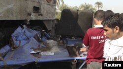 Keluarga para korban mengamati bis sekolah yang hancur setelah bertabrakan dengan kereta api di Manfalut dekat kota Assiut, 500 kilometer selatan Kairo (17/11). Lebih dari 40 anak-anak tewas dalam kecelakaan tersebut.