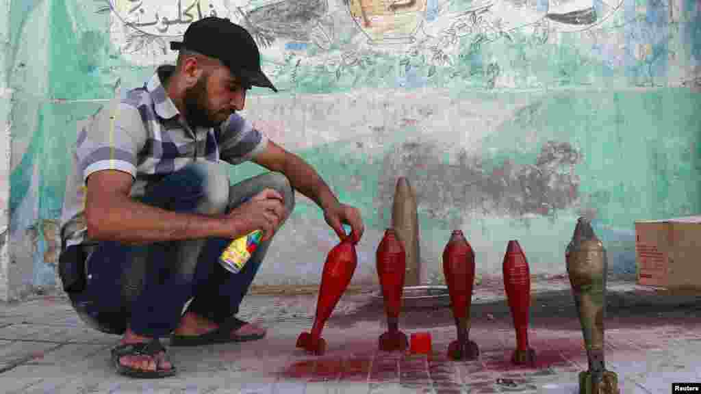 A Free Syrian Army fighter spray paints on improvised mortar shells at a weapons factory in Aleppo, Syria, Sept. 5, 2013.