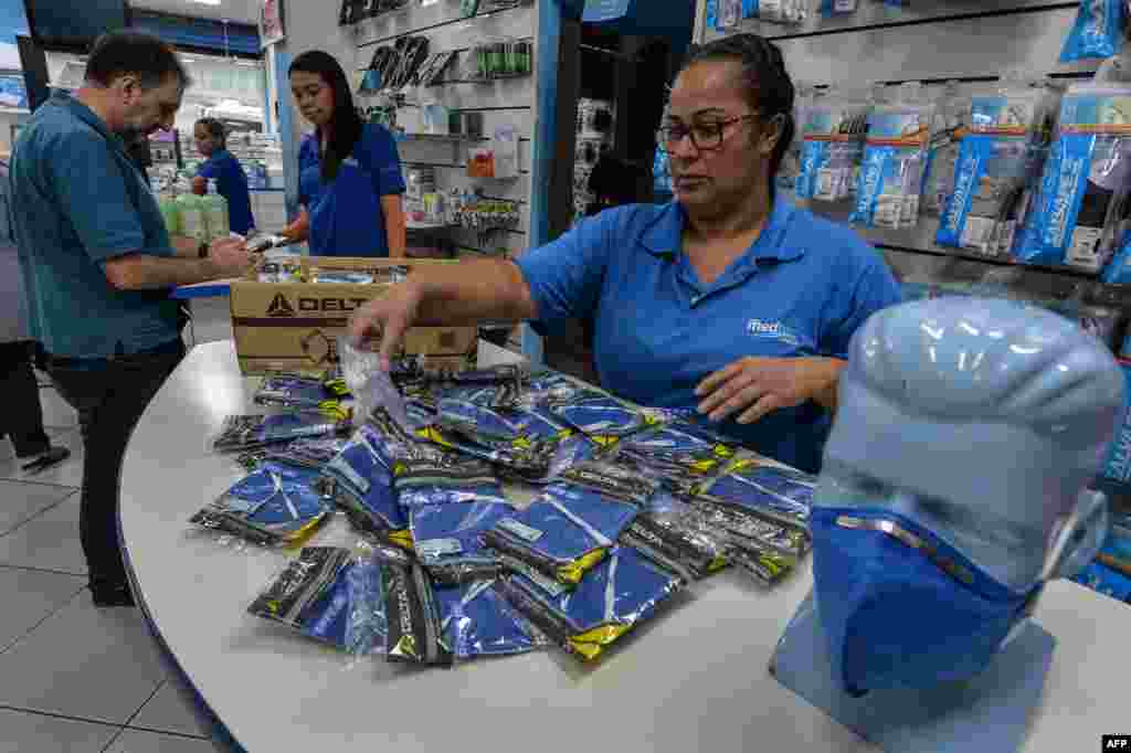 Una trabajadora de una tienda de suministros médicos, en Sao Paulo, Brasil, organiza máscaras de respirador PFF-2 que los clientes están comprando como medida de precaución contra la propagación del COVID-19. 