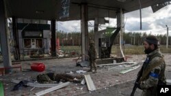 Soldados ucranianos encuentran el cadáver de un camarada caído en una gasolinera destruida en la ciudad recientemente recapturada de Lyman, en Ucrania, el 3 de octubre de 2022.