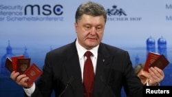 Germany -- Ukraine's President Petro Poroshenko holds Russian passports to prove the presence of Russian troops in Ukraine as he addresses during the 51st Munich Security Conference in Munich, February 7, 2015