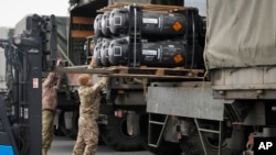 Militares ucranianos cargan misiles antitanque Javelin, entregados como parte de la asistencia de seguridad de Estados Unidos de América a Ucrania, en un camión militar en el aeropuerto de Boryspil, en las afueras de Kiev, Ucrania, el viernes 11 de febrero de 2022.