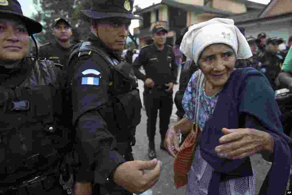 Seorang migran lansia Honduras berbicara dengan polisi Guatemala yang memblokir jalan untuk menghalangi agar dia dan rombongannya tidak meneruskan perjalanan, di Esquipulas, Guatemala, 15 Oktober 2018.