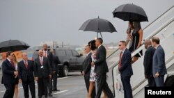 U.S. President Barack Obama and his wife Michelle approach Cuba's foreign minister Bruno Rodriguez as they arrive at Havana's international airport, March 20, 2016. 