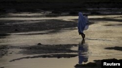 FILE - A woman walks across a river bed in Jalingo, Nigeria. REUTERS/Afolabi Sotunde 