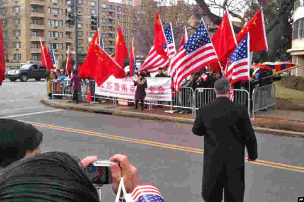 欢迎人群用旗帜挡住示威人士的抗议活动