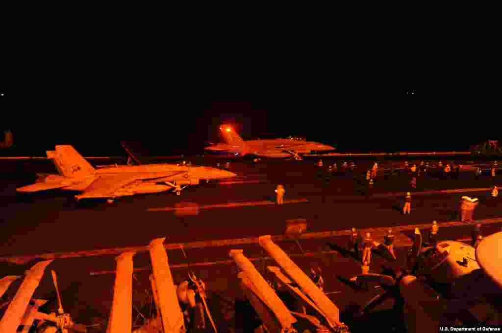 An F/A-18E Super Hornet, attached to Strike Fighter Squadron and an F/A-18F Super Hornet, attached to Strike Fighter Squadron 213, prepare to launch from the flight deck of the aircraft carrier USS George H.W. Bush to conduct strike missions against ISIL targets. George H.W. Bush is supporting maritime security operations and theater security cooperation efforts in the U.S. 5th Fleet area of responsibility, Arabian Gulf, Sept. 23, 2014. (U.S. Navy photo by Mass Communication Specialist 3rd Class Robert Burck/Released) 