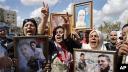 Palestinian women hold photos of relatives held in Israeli jails (file photo).