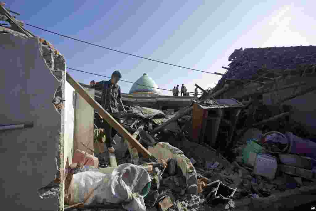 인도네시아 휴양지 롬복 섬에서 발생한 5.9 규모의 지진으로 무너진 가옥 잔해 사이로 남성이 걷고 있다. 지난 29일 이후 롬복 섬에서 세 번째 지진이 발생한 가운데 사망자 수는 계속해서 늘어날 것으로 보인다.