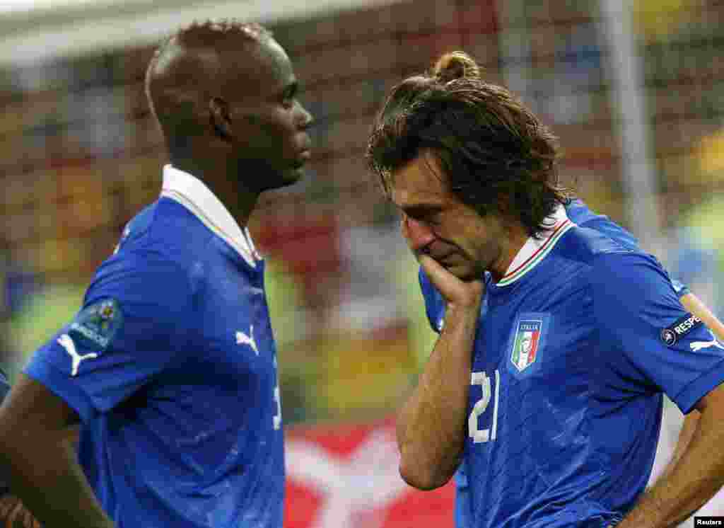 Italy's Andrea Pirlo (R) and Mario Balotelli react after losing their Euro 2012 final soccer match against Spain at the Olympic stadium in Kiev July 1, 2012.
