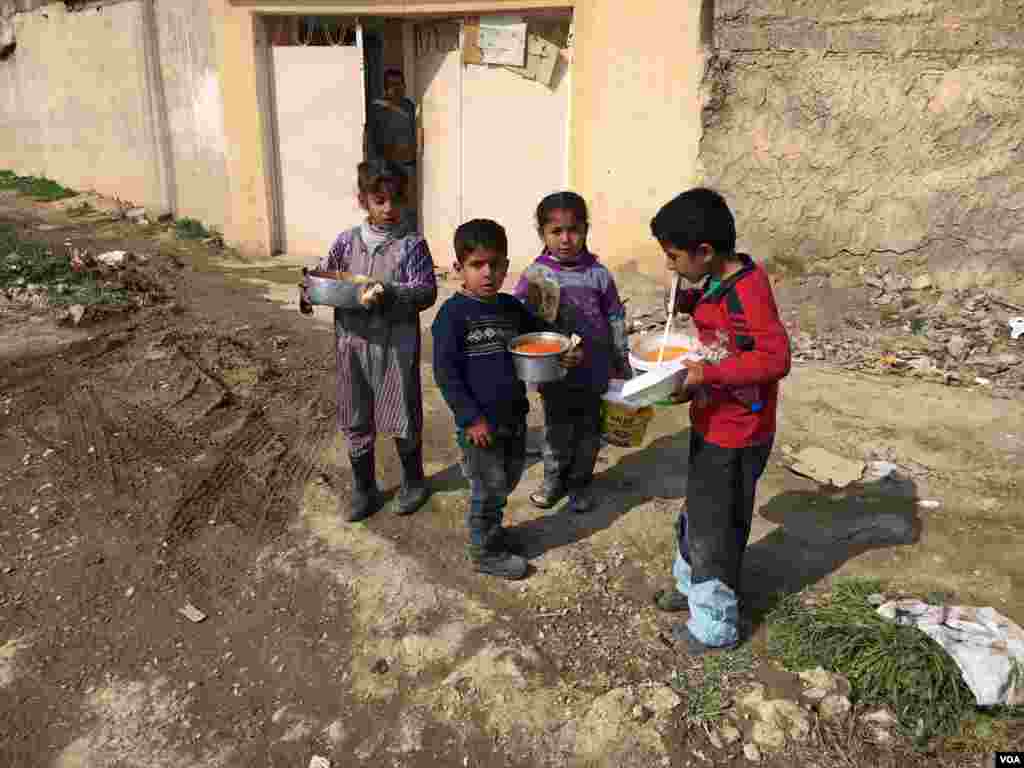 Kids from Arij village, west of Mosul get their food from Iraqi forces. (Kawa Omar/VOA Kurdish)