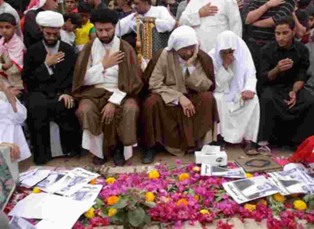 Mohamed Buhameed, front row second right, prays with clerics and mourners at the grave of his son, Abdel Redha Buhameed, in the western village of Malkiya, Bahrain, on Thursday, Feb. 24, 2011. Hundreds of people held a memorial protest march in honor of B