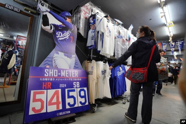 Customers shop for goods related to Shohei Ohtani of the Los Angeles Dodgers at a sporting goods store, "SELECTION," in Shinjuku district Wednesday, Oct. 23, 2024 in Tokyo. (AP Photo/Eugene Hoshiko)