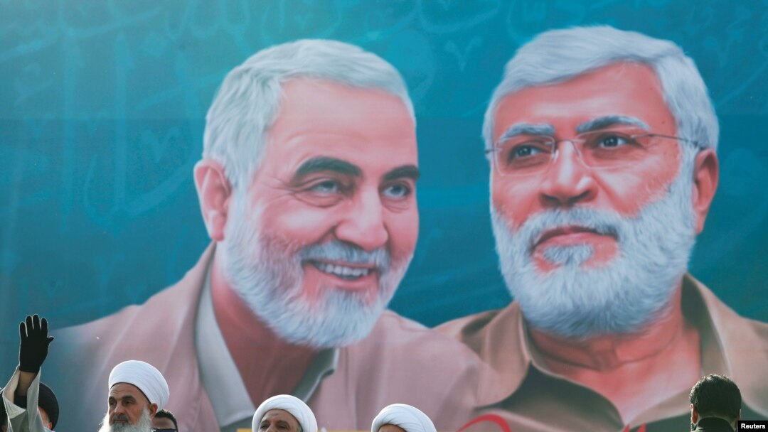 Sebuah mural yang menunjukkan wajah Jenderal Qassem Soleimani dan pemimpin komando milisi Irak Abu Mahdi al-Muhandis, terpampang di salah satu area di Baghdad dalam foto yang diambil pada 3 Januari 2021. (Foto: Reuters/Thaier Al-Sudani)