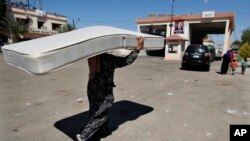 Una mujer siria que huye de la guerra en el Líbano carga un colchón cuando llega al cruce fronterizo sirio-libanés en Jousieh, Siria, el martes 2 de octubre de 2024. AP 