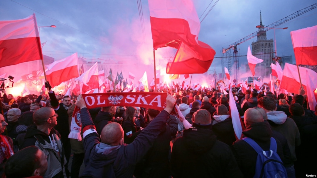 Protesters carry Polish flags and National Radical Camp flags during a rally, organized by far-right, nationalist groups, to mark 99th anniversary of Polish independence in Warsaw, Nov. 11, 2017.