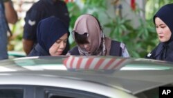 FILE - Vietnamese Doan Thi Huong (C) is escorted by police as she leaves the Shah Alam High Court after a hearing in Shah Alam, Malaysia, Nov. 7, 2018.