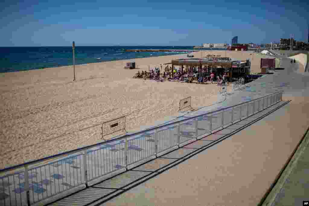 People gather on a terrace in a beach where access is not allowed in that time slot, in Barcelona, Spain.