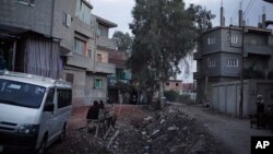 FILE - Women sit outside the clinic of Dr. Raslan Fadl, the doctor who performed the procedure of female genital mutilation on 13-year-old Soheir al-Batea that resulted in her death a year ago, in Aga, 120 kilometers (75 miles) northeast of Cairo, Egypt. 