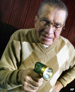 Eugene Polley, inventor of the wireless television remote control, holding his revolutionary device.