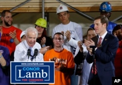 FILE - Former Vice President Joe Biden points at Conor Lamb, right, the Democratic candidate for the March 13 special election in Pennsylvania's 18th Congressional District, during a rally at the Carpenter's Training Center in Collier, Pennsylvania, March 6, 2018.