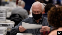 Cobb County Election officials handle ballots during an audit, Nov. 16, 2020, in Marietta, Georgia.