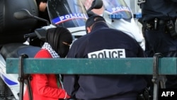 FILE - A French police officer speaks with a veiled Muslim woman during an identity check in Lille Sept. 22, 2012.