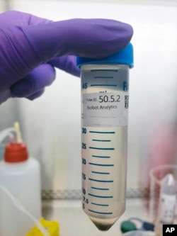 In this undated photo provided by Biobot in June 2020, a technician holds a wastewater sampling tube. Across the U.S. and in Europe, researchers and health officials say they can track the course of a community outbreak by studying the waste flushed from