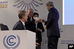 FILE—U.S. Special Presidential Envoy for Climate John Kerry, right, and Xie Zhenhua, China's special envoy for climate greet each other at the COP27 U.N. Climate Summit, Nov. 17, 2022, in Sharm el-Sheikh, Egypt.