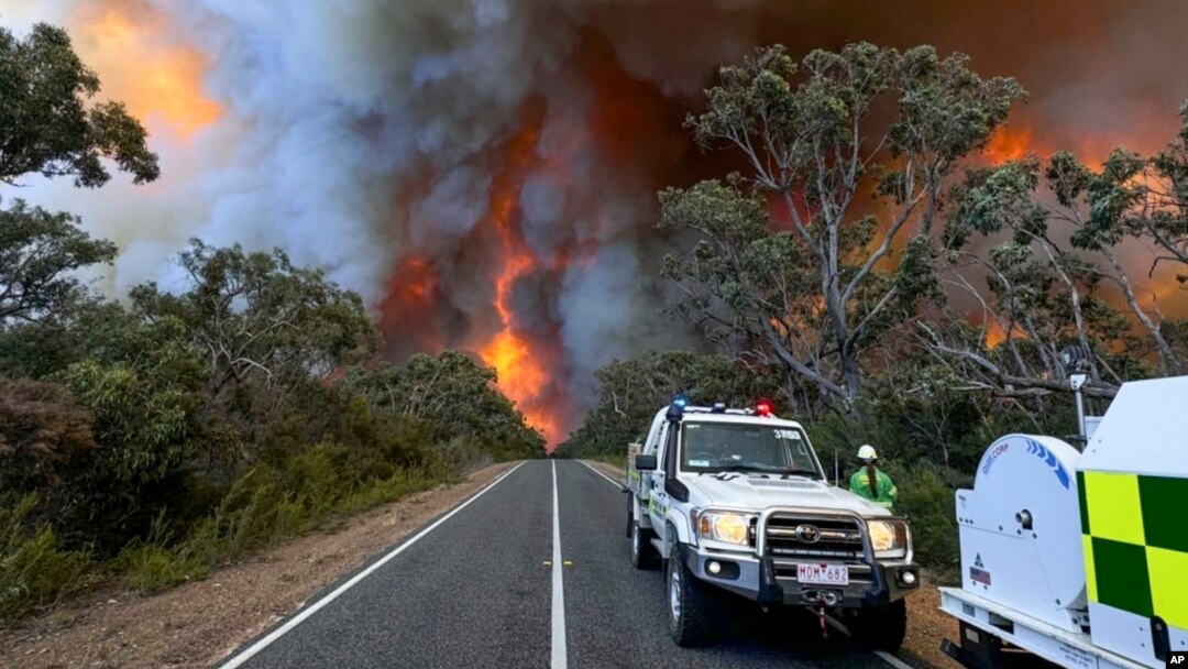 In this photo released by the State Control Centre, Country Fire Authority personnel watch as smoke billows from an out-of-control bushfire in Grampians National Park, in Victoria state, Australia, Dec. 20, 2024. 