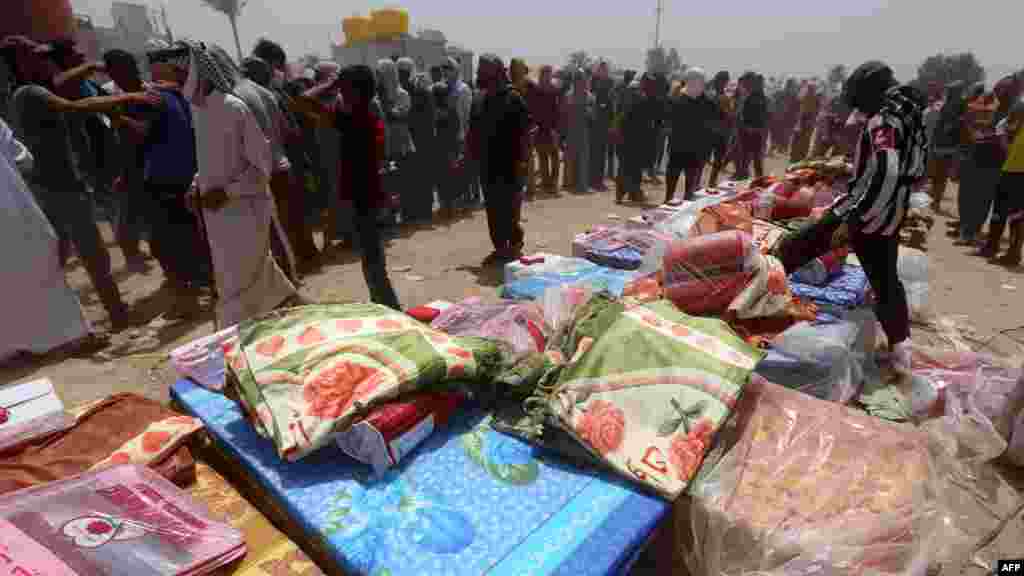 Iraqi families, who fled the city of Ramadi after it was seized by Islamic State militants, queue to receive aid at a camp for the internally displaced in Amriyat al-Fallujah, 30 kilometers south of Fallujah, May 22, 2015. 